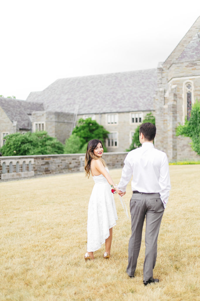 Bride and groom in a field in front of a stone church