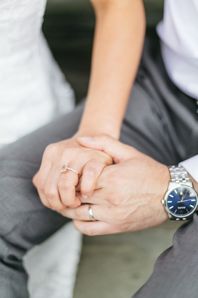 Close up of a couple holding hands with wedding rings