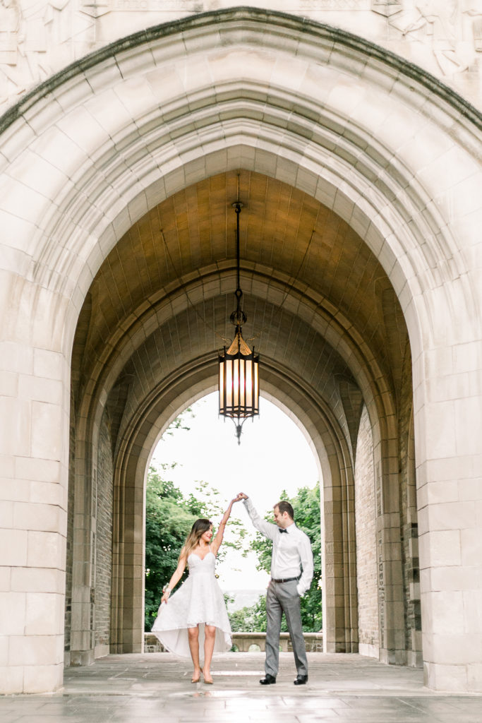 Bride and groom dancing in historic stone archway
