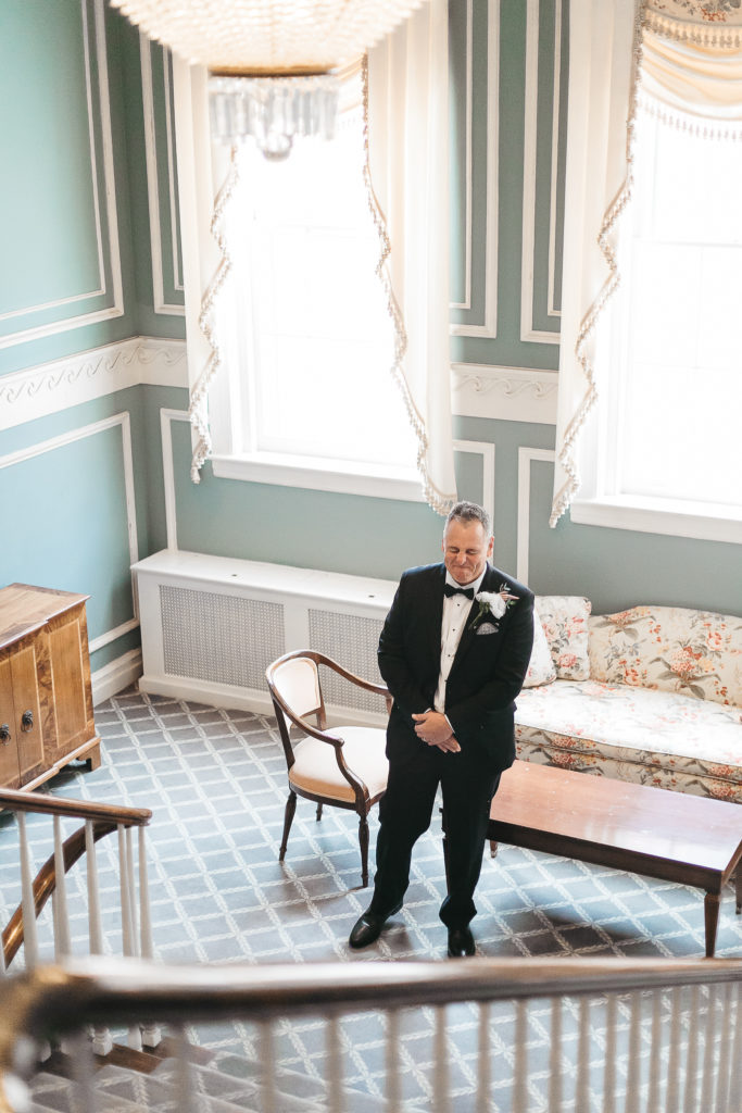 A father at the bottom of the staircase at the Genesee Valley Club, seeing his daughter in her wedding gown for the first time