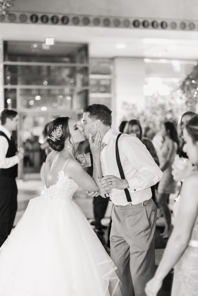 A candid image of a bride and groom kissing on the dancefloor at a Wintergarden wedding in Rochester, NY.