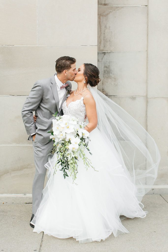 Wedding portrait of a bride and groom kissing in downtown Rochester, NY.