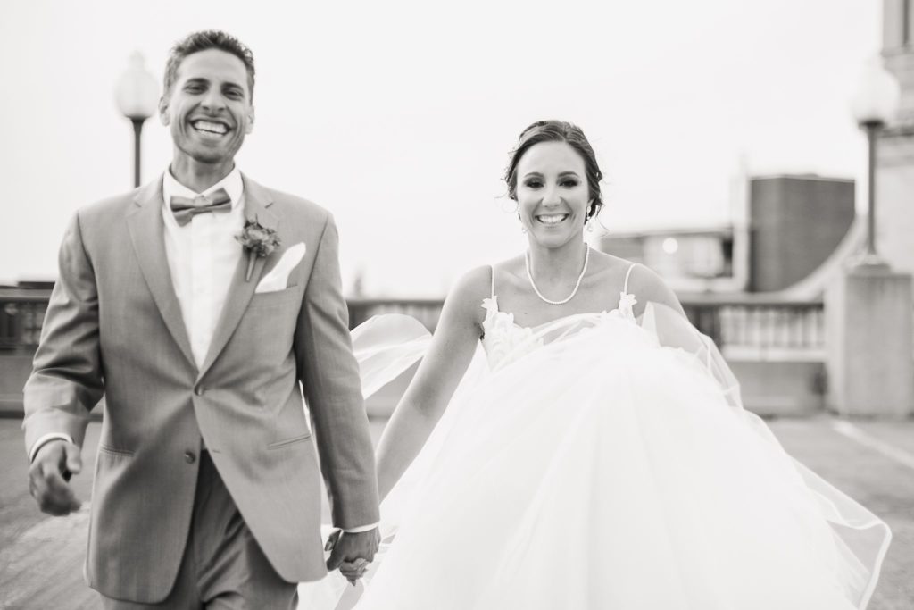 A bride and groom smiling widely after their Wintergarden wedding in Rochester, NY.