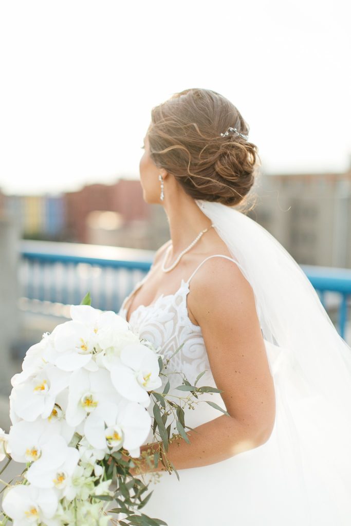 A bride on a Rochester, NY rooftop looking out over the sunset.
