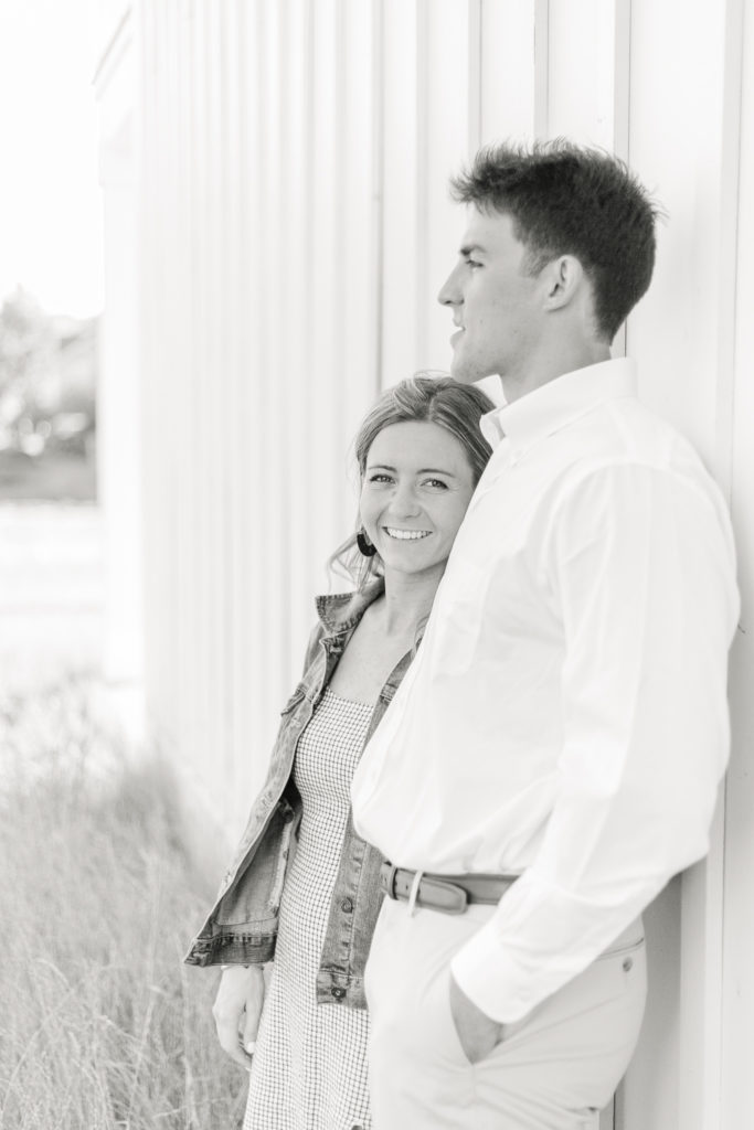 Black and white engagement portrait of a couple looking out over the water at The Lake House on Canandaigua.