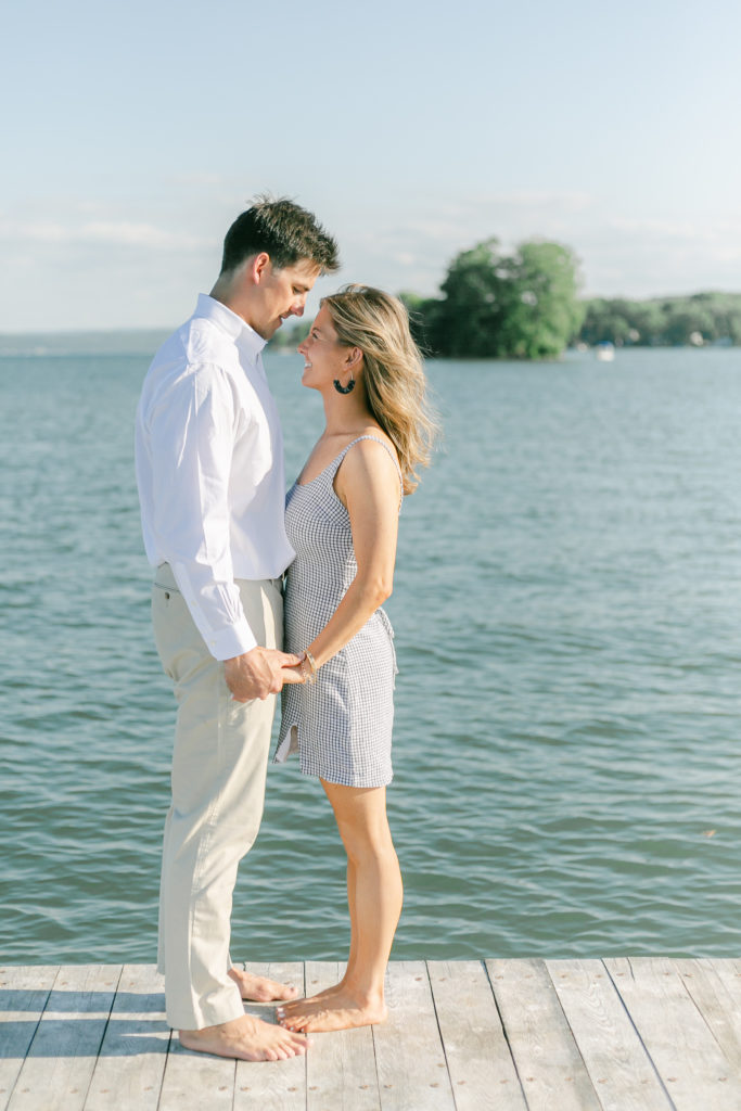 A couple standing on the docks along Canandaigua Lake during an engagement session.