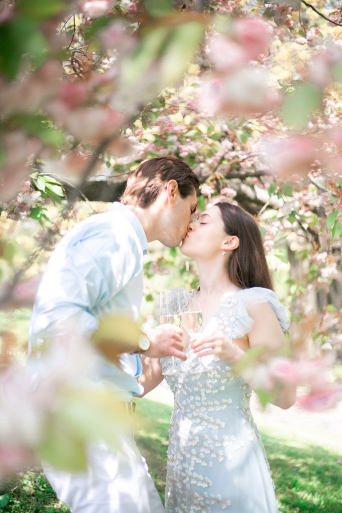 A couple kissing and toasting champagne during a Highland Park engagement session.