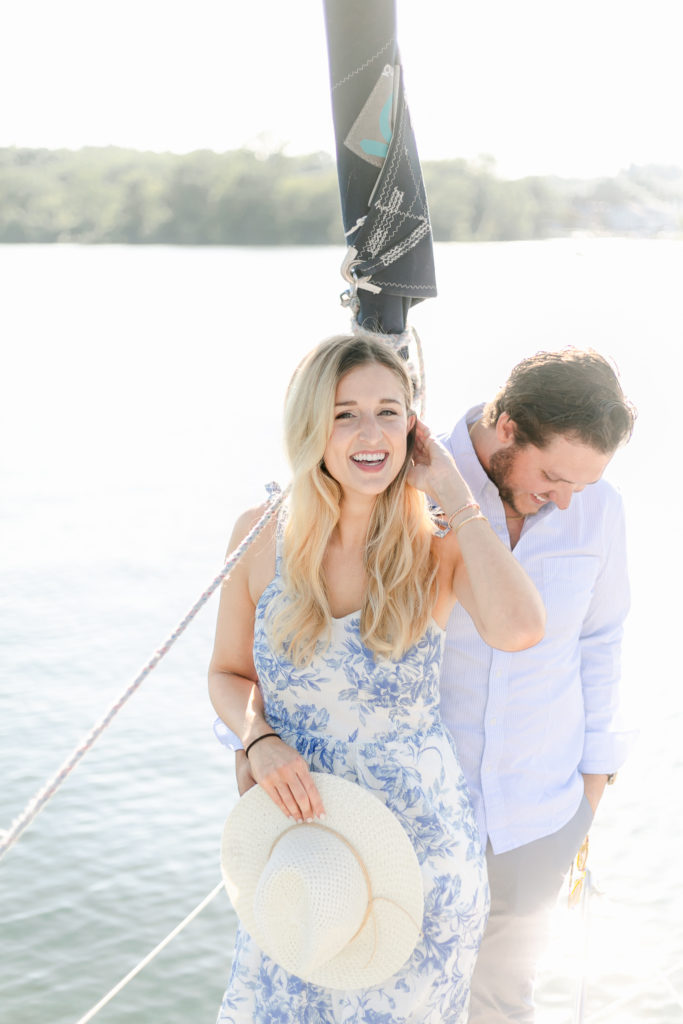 A couple laughing on a sailboat.