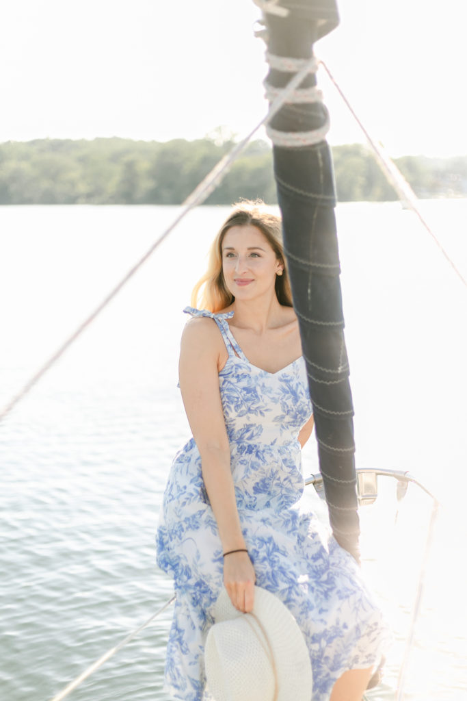 A woman sitting on a sailboat during a Canandaigua Lake engagement session.